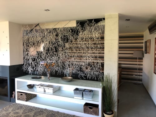 Recepción de Casa Arealonga en Vigo con mostrador blanco moderno, pared de acento negro con instalación botánica seca y