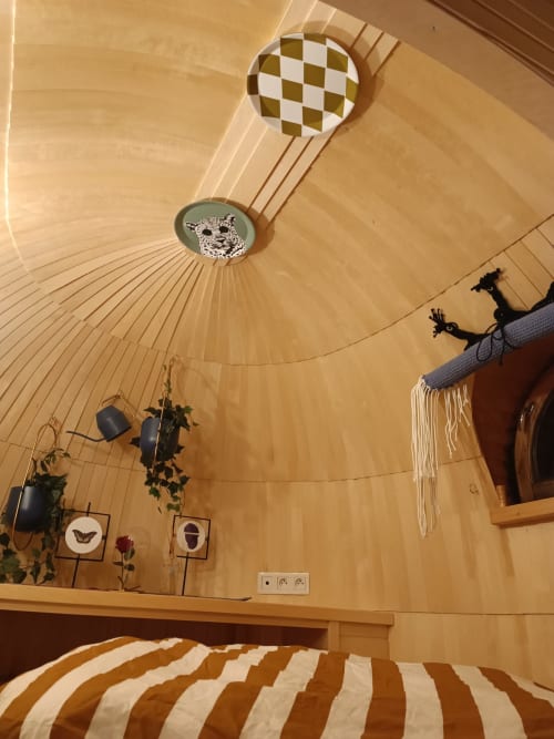 Cozy yurt bedroom at Les Refuges Du Chalet in Jalhay with wooden interior, striped bedding, and leopard artwork
