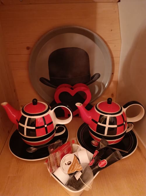 Red and black teapot set with bowls and tea accessories at Les Refuges Du Chalet cottage in Jalhay