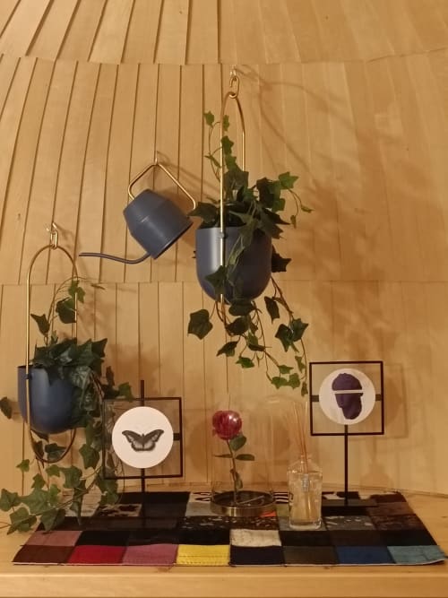 Garden view decor at Les Refuges Du Chalet cottage with hanging plants, botanical art, and colorful rug