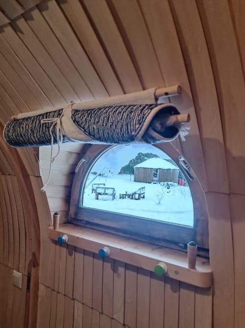 Fenster der Berghütte "The Bear's Lair" bei Les Refuges Du Chalet mit Blick auf den verschneiten Garten, Berghütte und Außenmöbel