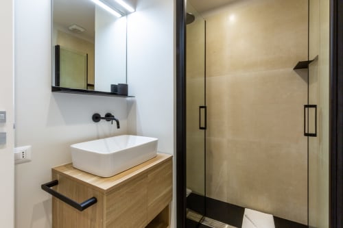 Bagno moderno di Casa Lounge Istria con lavabo da appoggio, mobile in legno e doccia in vetro a Cagliari