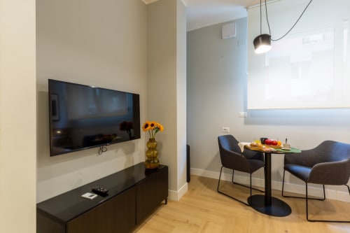 Camera moderna di Casa Lounge Istria a Cagliari con TV a schermo piatto, zona pranzo e vista sulla città