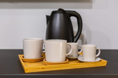 Servizio caffè con teiera nera e tazze bianche su vassoio in legno presso Casa Lounge Istria, Cagliari