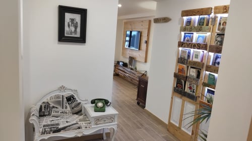 Vintage-inspired sitting area with newspaper, rotary phone, and wooden bookshelf in Obidos cottage