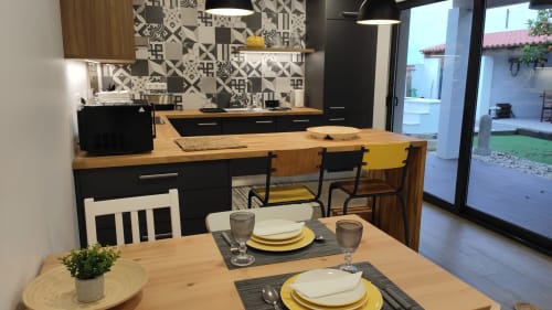 Modern kitchen and dining area in Laranjeira das Loiras cottage, Óbidos with geometric tiles, wooden counters, and table