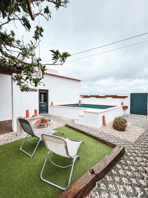 Cottage courtyard with lounge chairs, artificial grass, pool, and grill at Kindnessmoon in Óbidos, Portugal