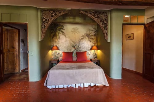 Jadezimmer im La Bouscatière B&B in Moustiers-Sainte-Marie mit roten Kissen, Palmen-Wandbild und Flussblick-Deko