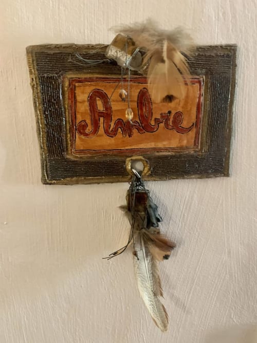 Rustikales Holzschild 'Ambre' mit Federverzierungen in La Bouscatière, Moustiers-Sainte-Marie