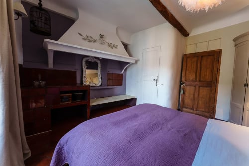 Zimmer Lula in La Bouscatière, Moustiers-Sainte-Marie mit violettem Steppbett, Holzmöbeln und sichtbaren Balkendecken