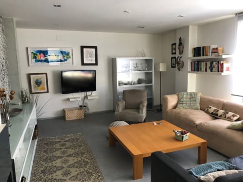 Sala moderna de la villa Casa Arealonga en Vigo con sofá beige, mesa de madera, arte mural y equipamiento de entretenimiento