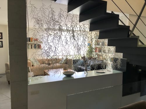 Recepción moderna del hotel Casa Arealonga en Vigo con arte de rama decorativa en la pared y escalera negra