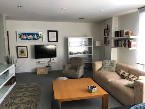Sala de estar moderna en Casa Arealonga de Vigo con sofá beige, mesa de café de madera, TV mural y estantes flotantes con