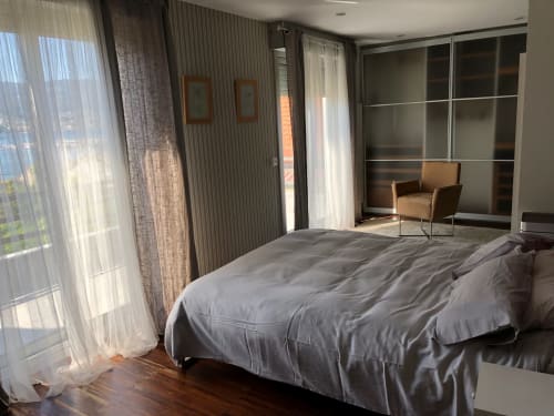 Dormitorio moderno en Casa Arealonga de Vigo con cama king, ventanales de piso a techo y vistas a la ciudad