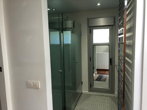 Baño moderno en Casa Arealonga, Vigo con ducha de cristal y piso de azulejos mosaico