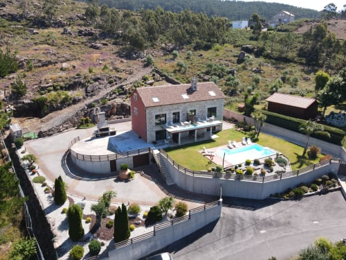 Hotel Ballenera de Caneliñas en Cee con piscina, terraza y paisaje boscoso circundante.