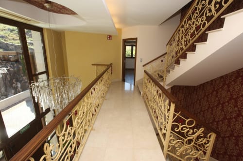 Moderno pasillo del hotel A Ballenera de Caneliñas en Cee con barandillas ornamentales y escalera