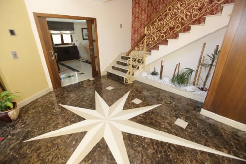 Foyer moderno de A Ballenera de Caneliñas en Cee con estrella decorativa en el suelo, escalera de madera y plantas en macetas