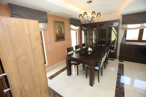 Comedor moderno del hotel A Ballenera de Caneliñas en Cee con mesa de madera oscura, sillas negras y elegante lámpara de araña