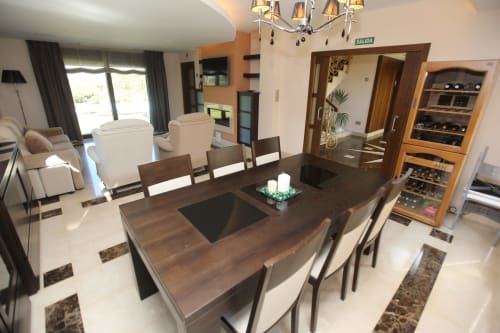 Área moderna de comedor y sala en el hotel A Ballenera de Caneliñas en Cee con mesa de madera, asientos cómodos y