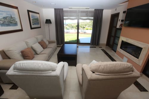 Acogedora sala de estar moderna del hotel con sofás confortables, chimenea y vistas a la terraza en A Ballenera de Caneliñas en Cee
