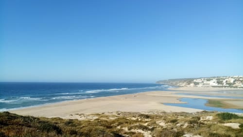 Praia costeira com dunas de areia e estuário perto de Óbidos, Portugal em dia claro e ensolarado