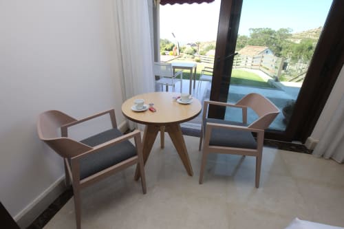Zona de estar moderna en habitación de hotel de A Ballenera de Caneliñas en Cee con mesa redonda, sillas de madera y vistas al rural
