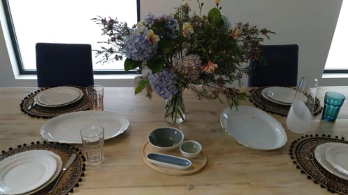 Mesa de comedor elegante en Casa Arealonga Vigo con cubiertos, flores frescas y luz natural