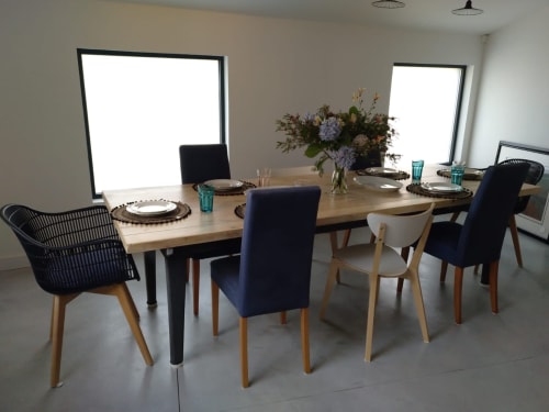 Comedor moderno de Casa Arealonga, Vigo con mesa de madera, asientos variados, centro floral y luz natural