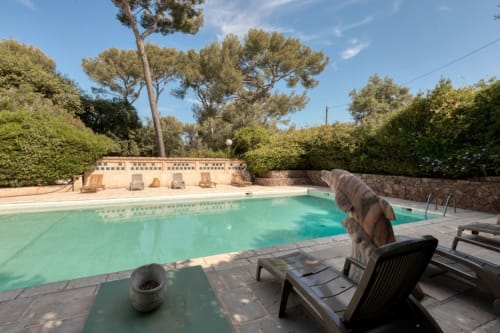 Piscine du Camping La Lézardière à La Valette du Var avec transats, murs en pierre et arbres méditerranéens