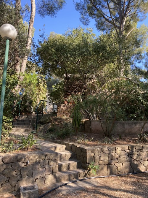 Escalier en pierre et lampadaire dans le jardin verdoyant du Camping La Lézardière, La Valette du Var