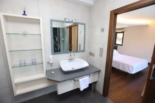 Baño moderno en habitación Temerario del hotel A Ballenera de Caneliñas en Cee con doble lavabo, espejo y vistas al mar