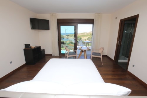 Habitación Temerario en el hotel A Ballenera de Caneliñas en Cee con balcón con vistas al mar, cama, TV y comodidades modernas