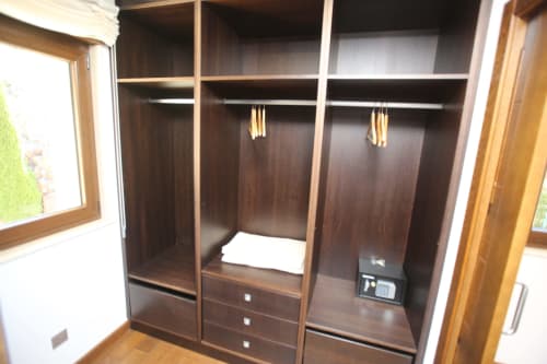 Armario empotrado de madera con barras de colgar, cajones y caja de seguridad en la habitación Temerario de A Ballenera de Caneliñas