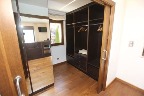 Moderno vestidor con armarios negros y puertas de madera en la habitación Temerario con vistas al mar del hotel A Ballenera de Caneliñas, Cee