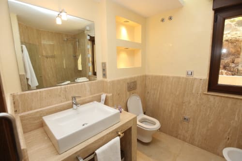 Baño moderno con paredes de madera, lavabo rectangular blanco, inodoro y cabina de ducha en el hotel Ballenera de Caneliñas