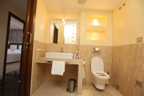 Baño moderno en la habitación Carrumeiro del hotel A Ballenera de Caneliñas en Cee, con lavabo, inodoro y toallero calefactable