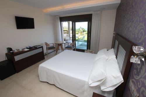 Habitación Carrumeiro en A Ballenera de Caneliñas (Cee) con balcón con vistas al mar, cama blanca, TV y equipamientos modernos