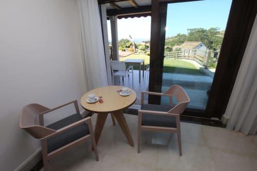 Sala Carrumeiro en A Ballenera de Caneliñas con sillas de madera, mesa redonda y vistas al mar de Cee, Galicia