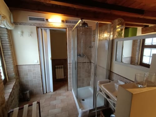 Amplio baño en La Posada Del Tiétar con ducha de cristal, lavabo y vigas de madera en Santa María del Tiétar