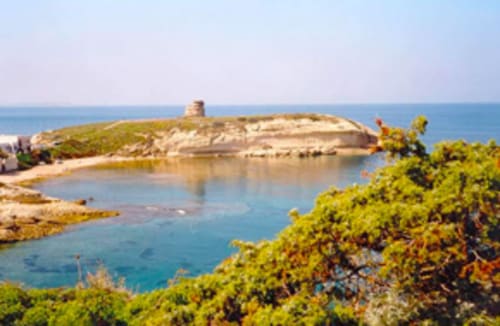 Vista costiera di Torre Grande Oristano con penisola rocciosa, acque turchesi e vegetazione mediterranea
