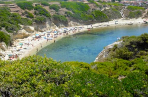 Affascinante caletta costiera a Torre Grande Oristano con acque turchesi, spiaggia sabbiosa e vegetazione mediterranea