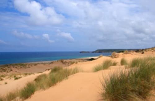 Spiaggia sabbiosa con erbe dunali affacciata sul blu Mar Mediterraneo vicino a Torre Grande, Oristano