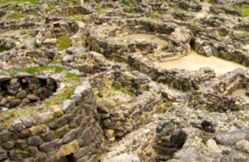 Paisaje costero rocoso con piedras cubiertas de musgo en Torre Grande, Oristano, Italia