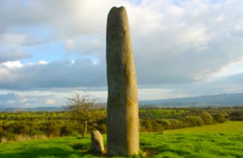 Antigua piedra enhiesta en campos verdes cerca de Torre Grande, Oristano, paisaje campestre italiano