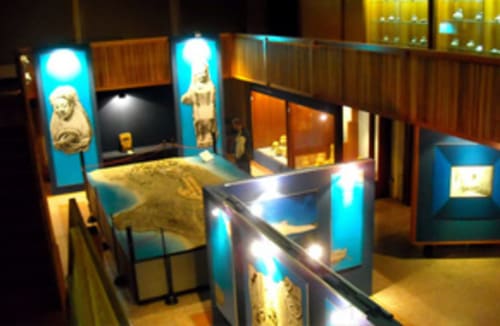Exposition d'artefacts égyptiens au musée d'Affittacamere Al Mare, Torre Grande Oristano avec vitrines illuminées et statues
