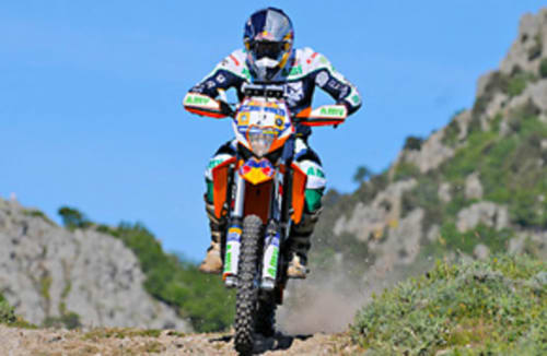 Motocross-Fahrer auf Schmutzrad im Felsengelände nahe Torre Grande Oristano