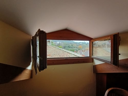 Ventanas de madera abiertas con vistas a tejados y colinas verdes en La Posada Del Tiétar, Santa María del Tiétar