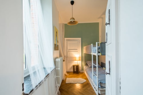 Chambre lumineuse au Château De La Malmaison en Champagne avec lits superposés, murs vert sauge, parquet et vue sur le jardin