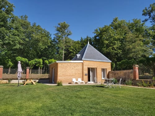 Chalet moderne en bois avec toit pointu au Château de La Malmaison à Aÿ-Champagne, entouré de jardins soignés
